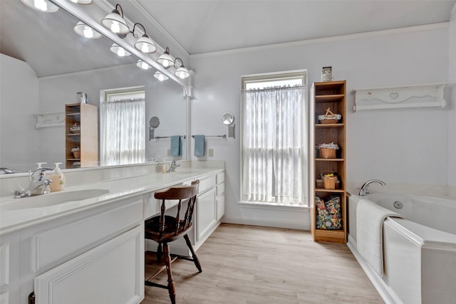 bathroom with vanity, lofted ceiling, a bathing tub, crown molding, and hardwood / wood-style flooring