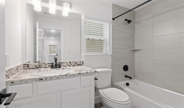 full bathroom with vanity, toilet, plenty of natural light, and tiled shower / bath