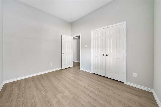 unfurnished bedroom featuring light wood-type flooring and a closet