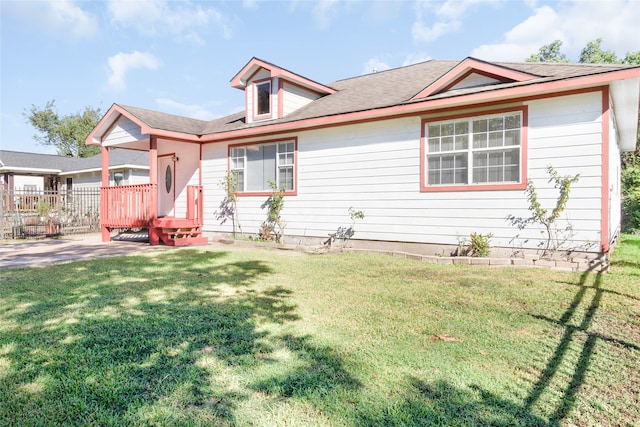 view of front of home with a wooden deck and a front yard