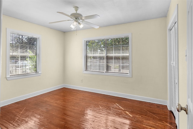 unfurnished bedroom featuring a closet, wood-type flooring, multiple windows, and ceiling fan