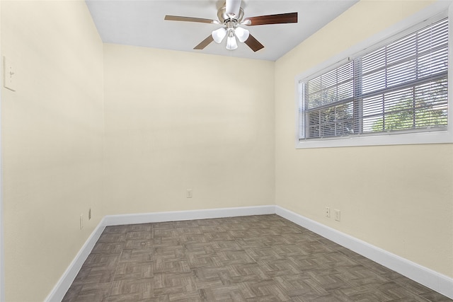 empty room featuring ceiling fan and dark parquet floors