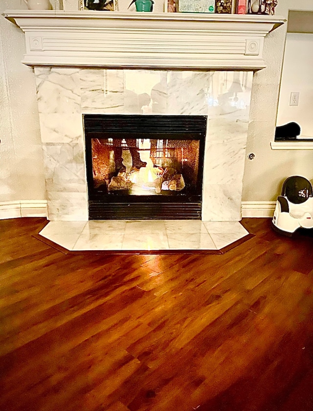 interior details with hardwood / wood-style flooring and a tile fireplace