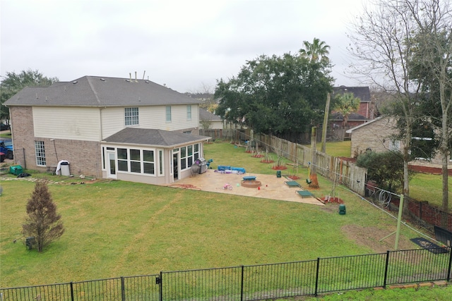 rear view of house featuring a yard, a patio area, and a sunroom