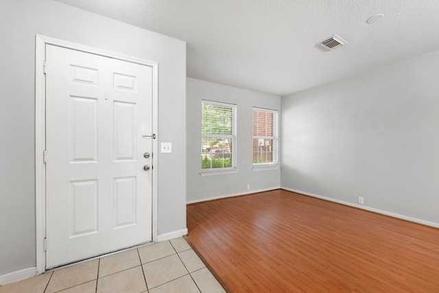 foyer featuring a textured ceiling and light hardwood / wood-style floors