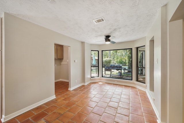 tiled empty room with a textured ceiling and ceiling fan