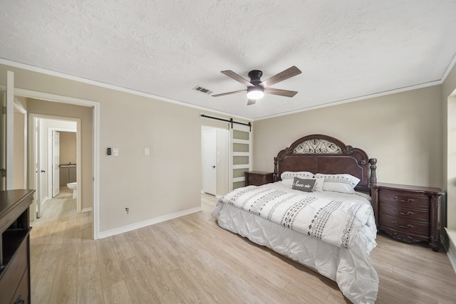 bedroom with a barn door, a textured ceiling, crown molding, ceiling fan, and light hardwood / wood-style flooring