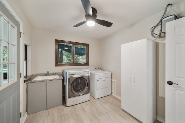 washroom with light hardwood / wood-style floors, independent washer and dryer, ceiling fan, cabinets, and sink