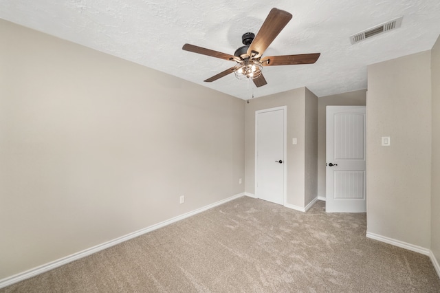 unfurnished bedroom featuring a textured ceiling, ceiling fan, and light colored carpet