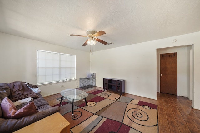 living room featuring a textured ceiling, dark hardwood / wood-style floors, and ceiling fan