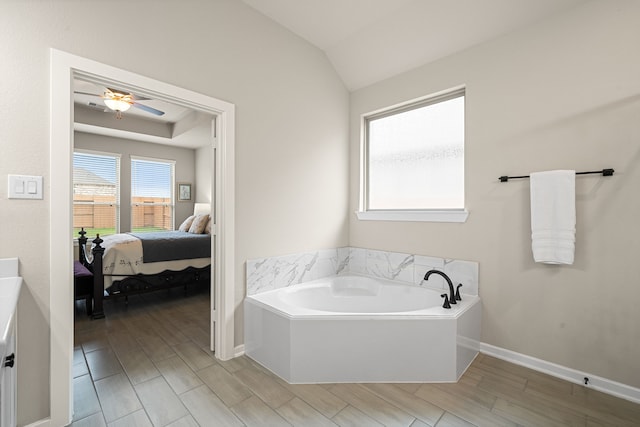 bathroom featuring lofted ceiling, ceiling fan, hardwood / wood-style flooring, and a tub