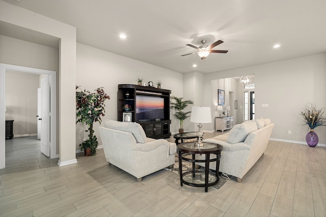 living room featuring light hardwood / wood-style flooring and ceiling fan with notable chandelier