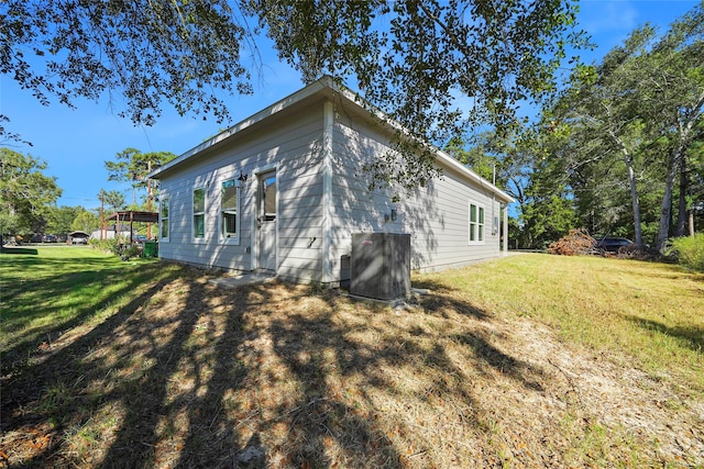 view of home's exterior featuring a lawn and central AC unit