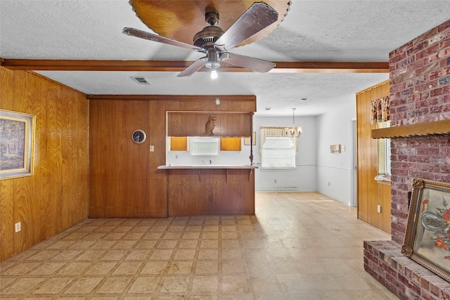 kitchen featuring a textured ceiling, hanging light fixtures, and kitchen peninsula