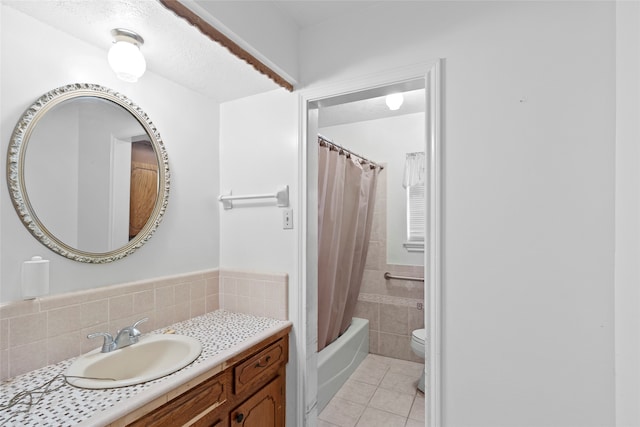 full bathroom with tile walls, vanity, shower / bath combo, toilet, and tile patterned floors