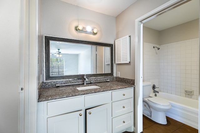 full bathroom featuring tiled shower / bath combo, vanity, toilet, and tile patterned floors