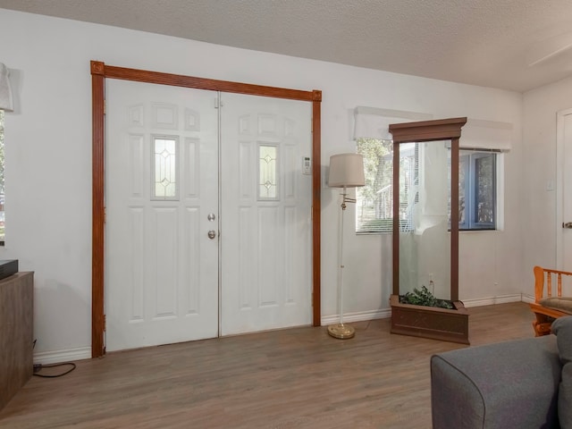 foyer entrance with a textured ceiling and hardwood / wood-style floors