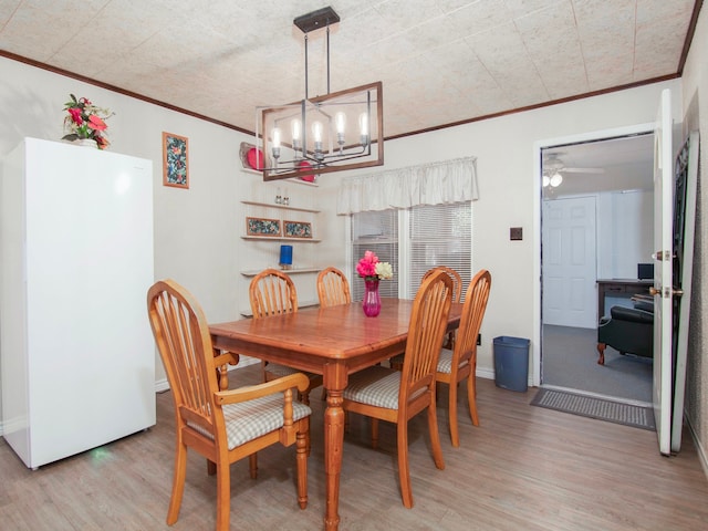 dining area with ceiling fan with notable chandelier, crown molding, and light hardwood / wood-style floors