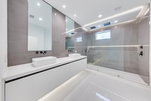 bathroom with vanity, tile walls, and a tile shower