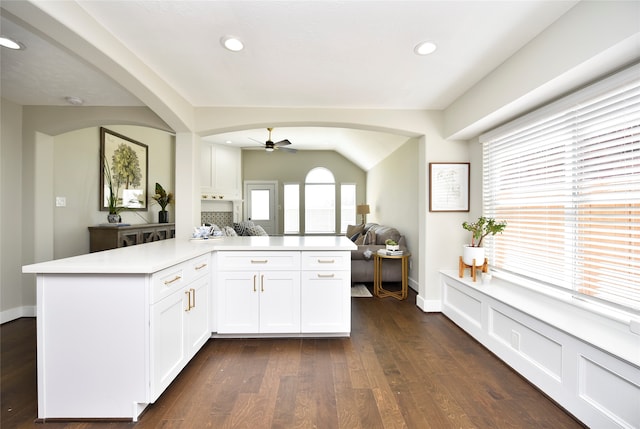 kitchen featuring white cabinetry, backsplash, kitchen peninsula, dark hardwood / wood-style flooring, and ceiling fan