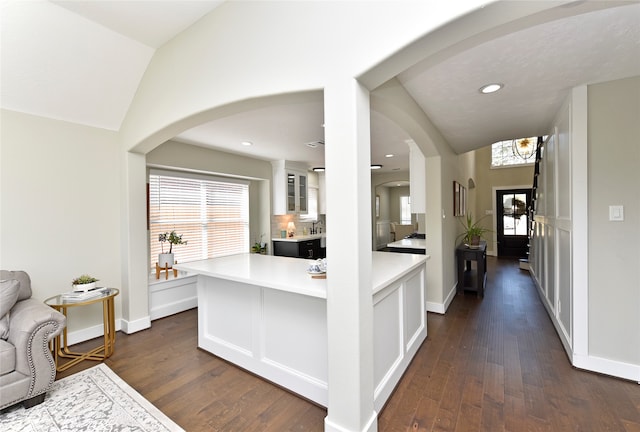 kitchen featuring tasteful backsplash, vaulted ceiling, dark hardwood / wood-style floors, and white cabinets