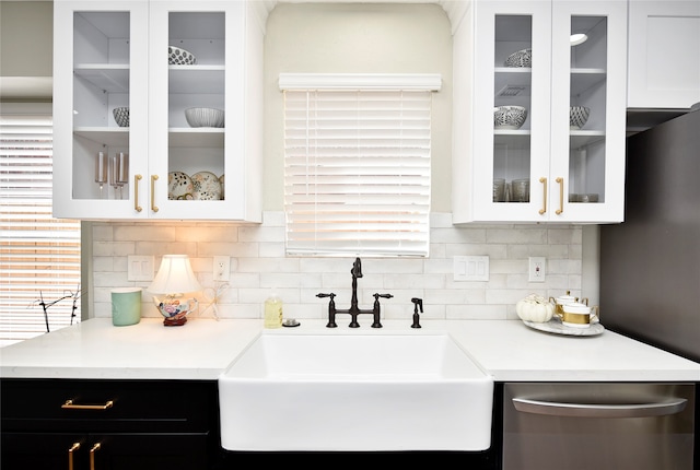 kitchen with backsplash, white cabinetry, dishwasher, and sink