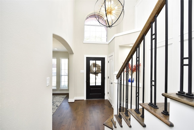 foyer entrance featuring an inviting chandelier, a high ceiling, and dark hardwood / wood-style flooring