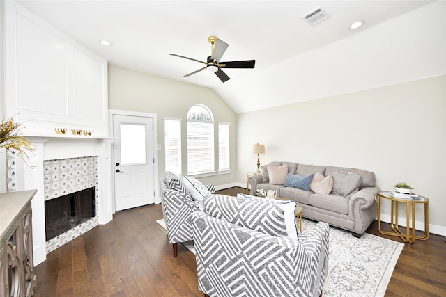 living room with lofted ceiling, ceiling fan, a tile fireplace, and dark hardwood / wood-style floors