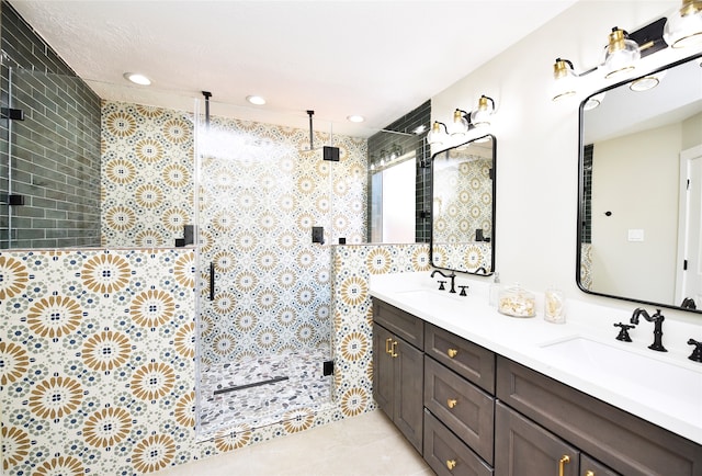 bathroom with walk in shower, vanity, and tile patterned floors