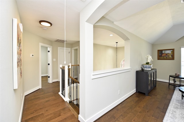 hallway featuring vaulted ceiling and dark hardwood / wood-style flooring