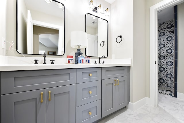 bathroom with tiled shower and vanity