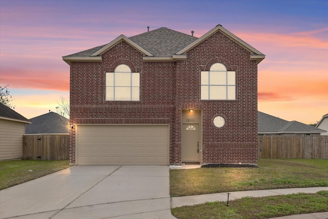 view of property featuring a garage and a yard