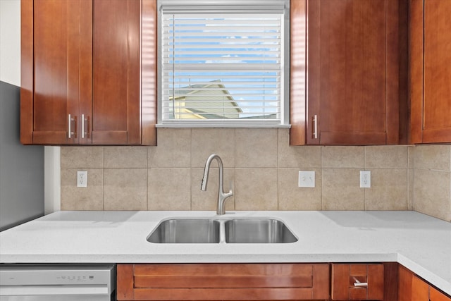 kitchen featuring dishwashing machine, sink, and tasteful backsplash