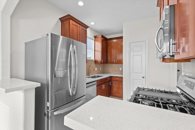 kitchen with stainless steel appliances, light stone counters, tasteful backsplash, and sink