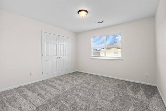 unfurnished bedroom featuring carpet and a closet