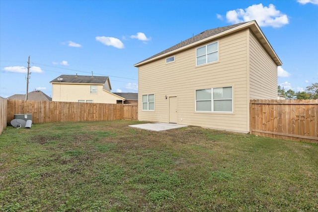 rear view of property featuring a yard and a patio