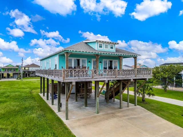 rear view of house featuring a lawn, a carport, and covered porch