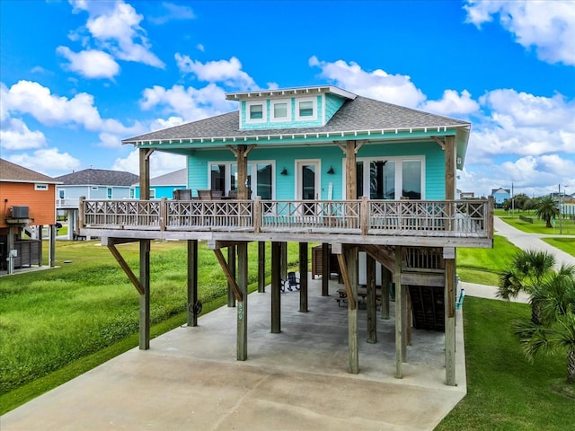 back of property featuring a lawn and covered porch