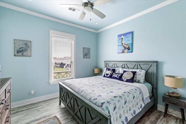 bedroom featuring light hardwood / wood-style flooring, ceiling fan, and crown molding