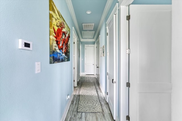 hall with light wood-type flooring and crown molding