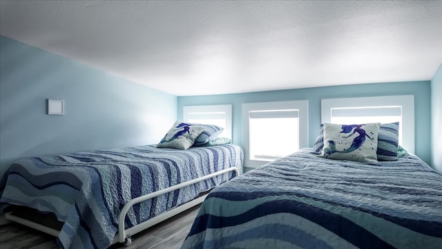 bedroom with a textured ceiling and hardwood / wood-style floors