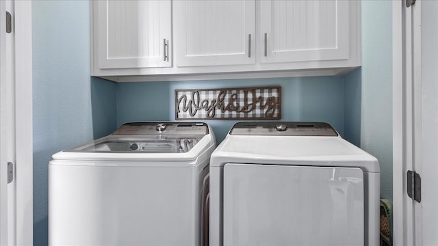 washroom with cabinets and washer and dryer