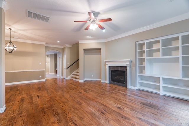 unfurnished living room with ceiling fan, hardwood / wood-style flooring, crown molding, and a tile fireplace