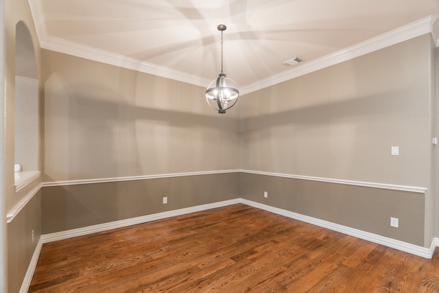 spare room featuring hardwood / wood-style flooring, crown molding, and a notable chandelier