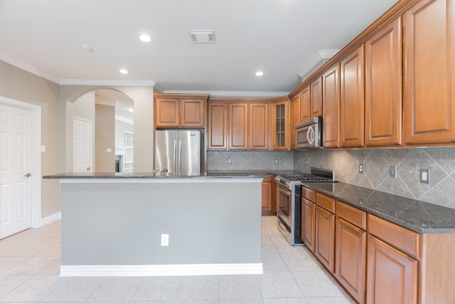 kitchen featuring appliances with stainless steel finishes, backsplash, dark stone countertops, and light tile patterned flooring