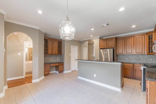 kitchen with decorative light fixtures, stainless steel appliances, crown molding, and a kitchen island