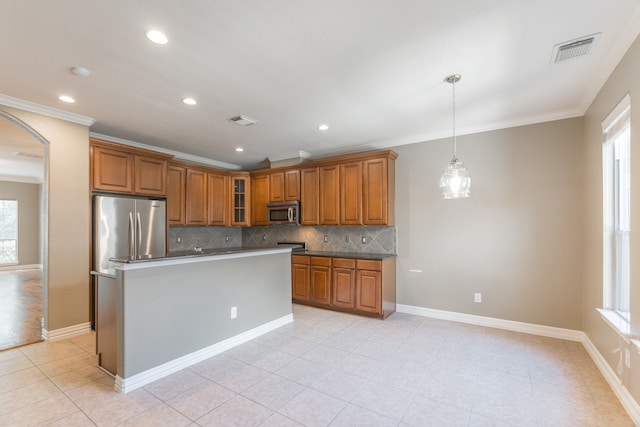 kitchen with appliances with stainless steel finishes, backsplash, and a healthy amount of sunlight