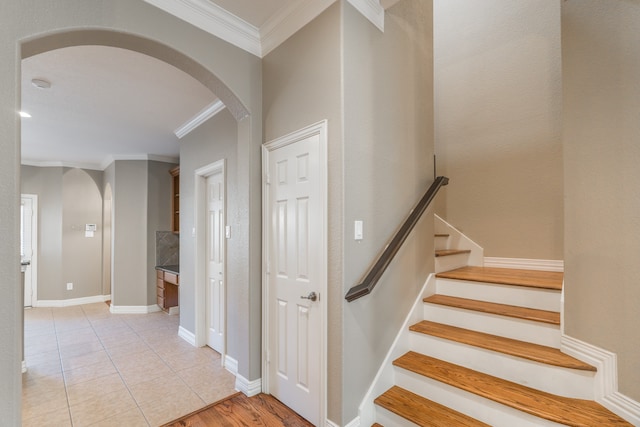 stairs featuring crown molding and tile patterned flooring