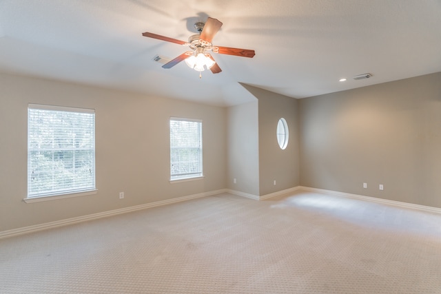 carpeted empty room featuring a healthy amount of sunlight and ceiling fan