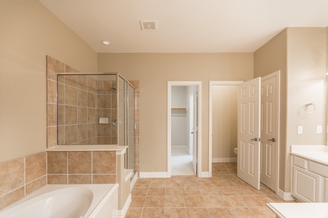 full bathroom featuring vanity, shower with separate bathtub, toilet, and tile patterned floors